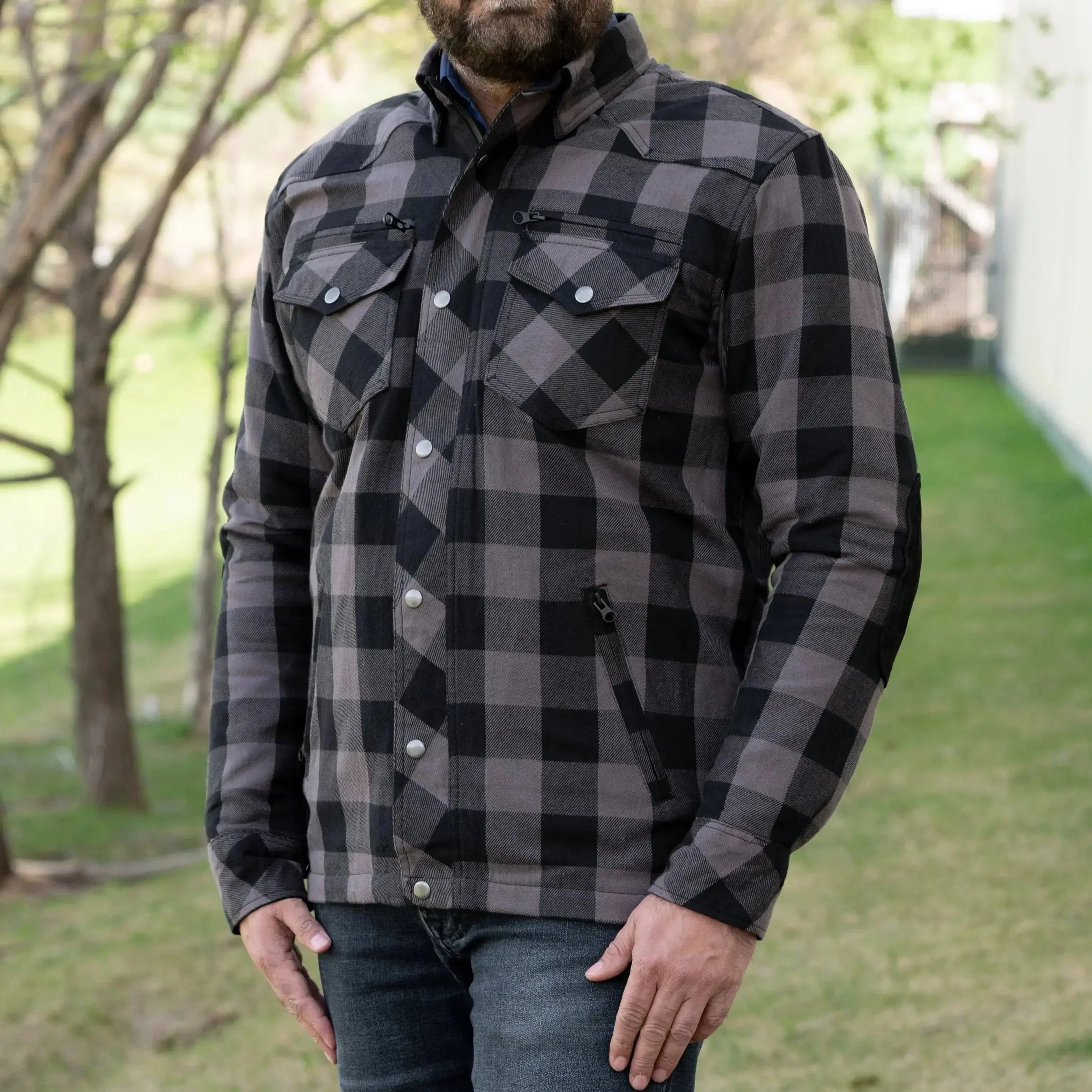 Man wearing black and grey plaid flannel shirt jacket outdoors
