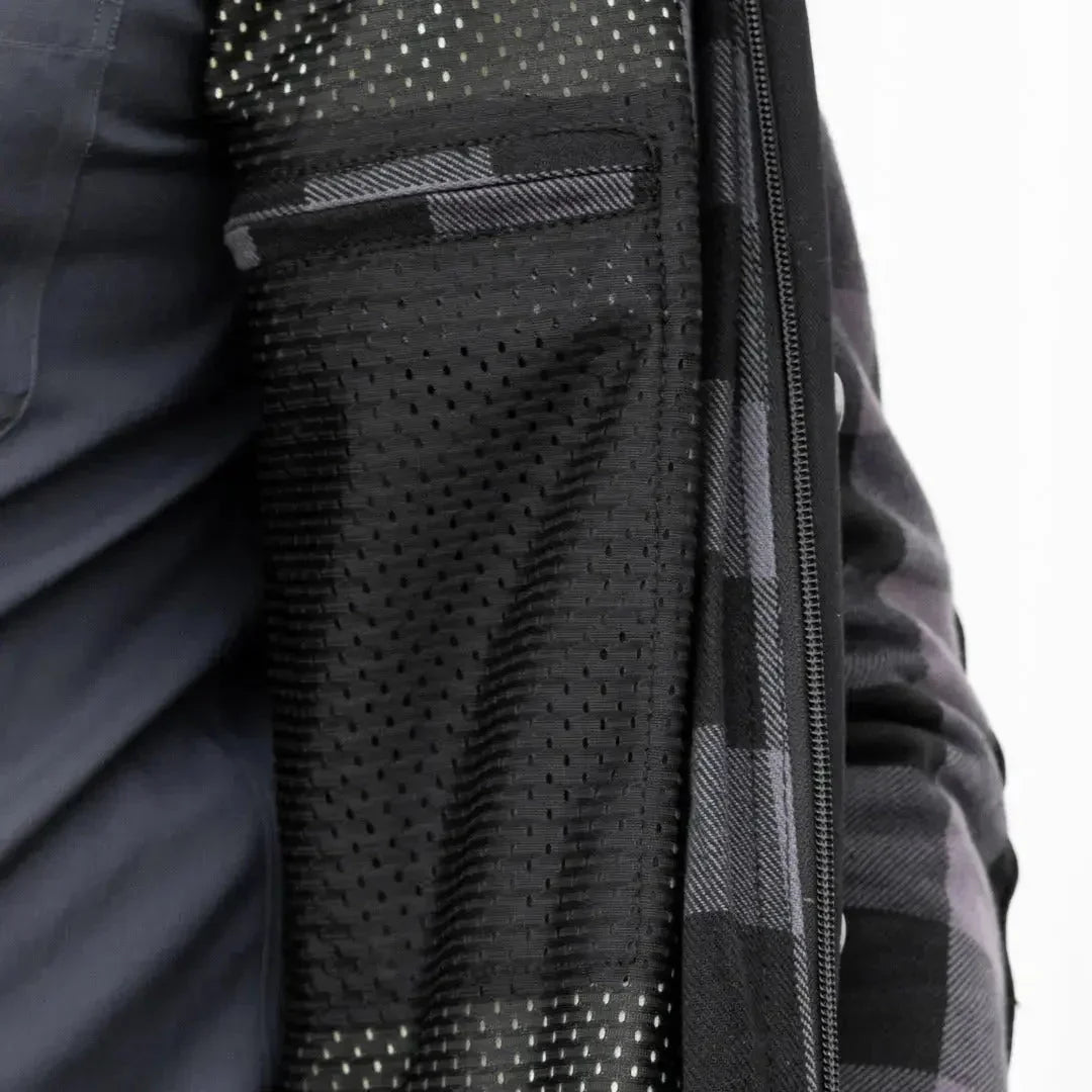 Close up of black perforated mesh interior pocket on plaid jacket with zipper