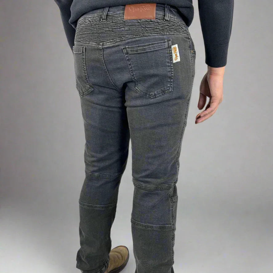 Back view of person wearing grey jeans with patchwork details and leather brand label