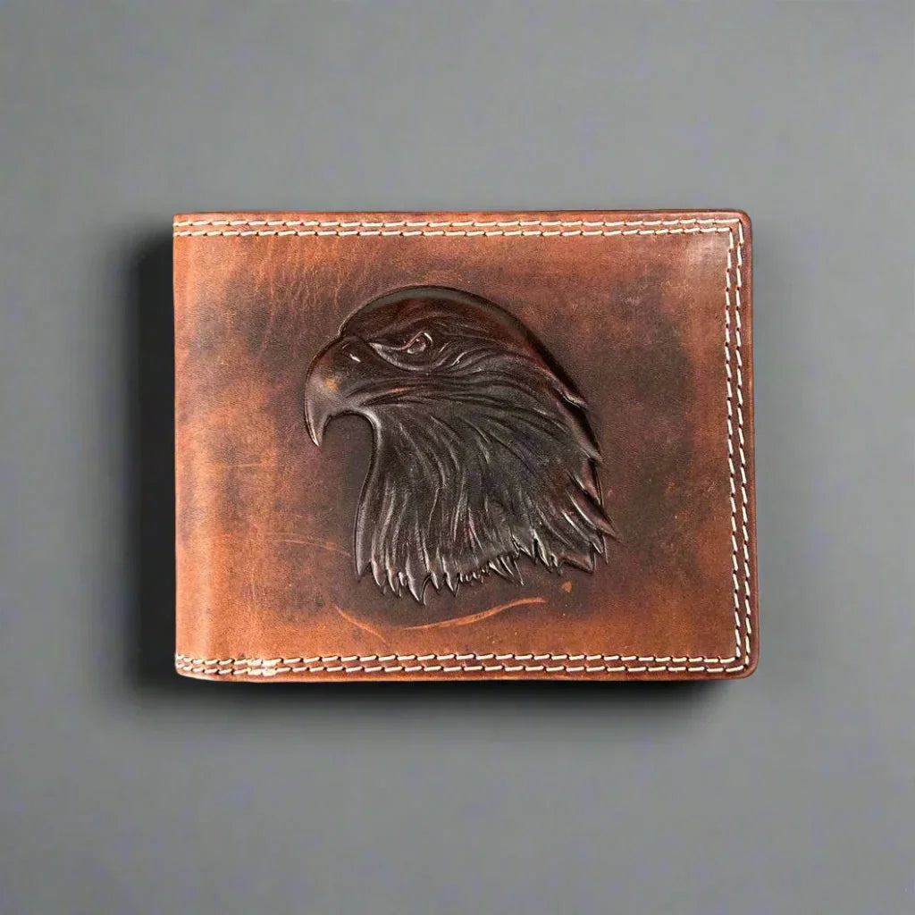 Brown leather wallet with embossed eagle head design and white stitching on gray background