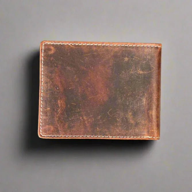 Brown vintage leather wallet with visible stitching on a gray background.