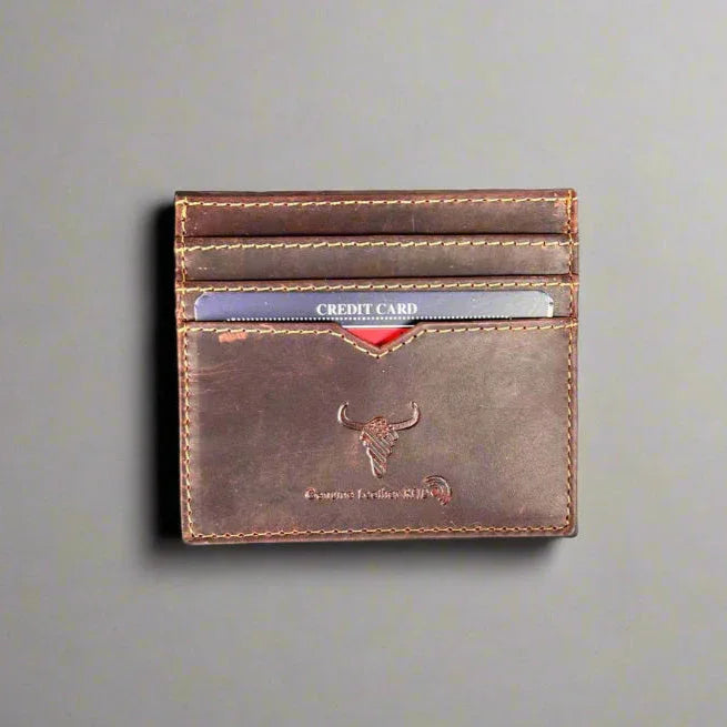 Brown leather card holder with credit cards, embossed logo, and stitched detail on gray background
