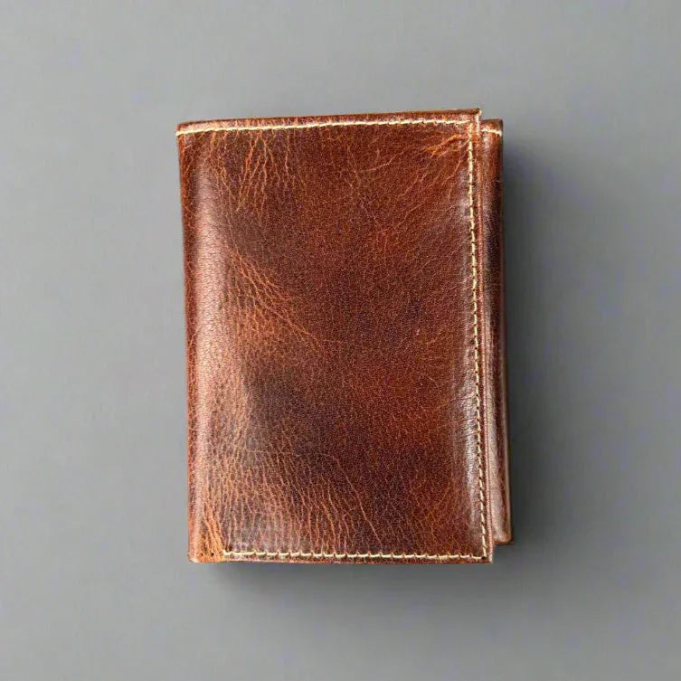 Brown genuine leather wallet on a grey background, minimalist men's accessory