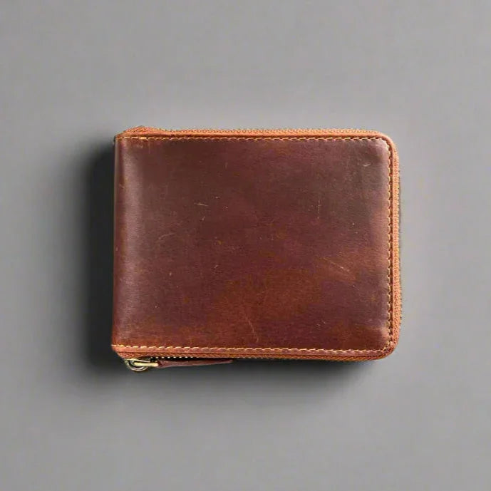 Brown leather wallet with zipper on gray background