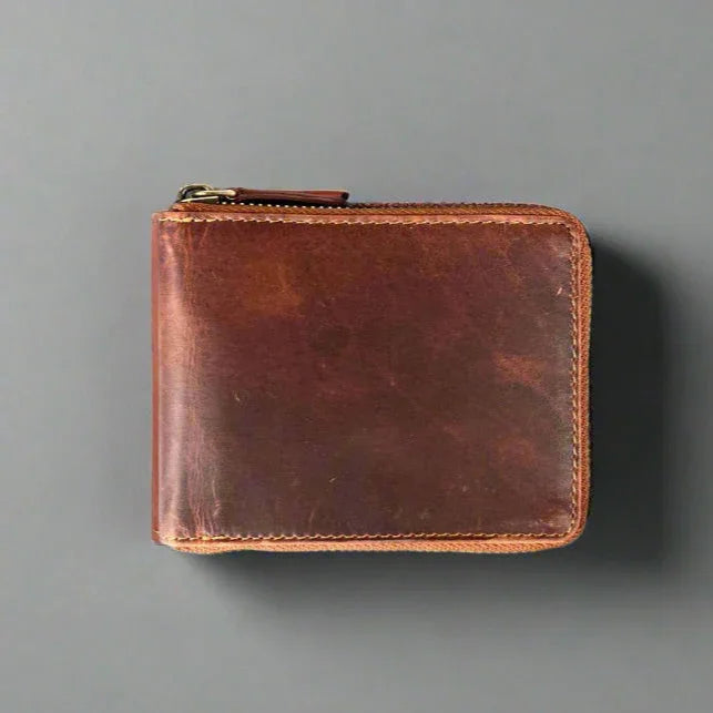 Brown leather zip wallet on a gray background