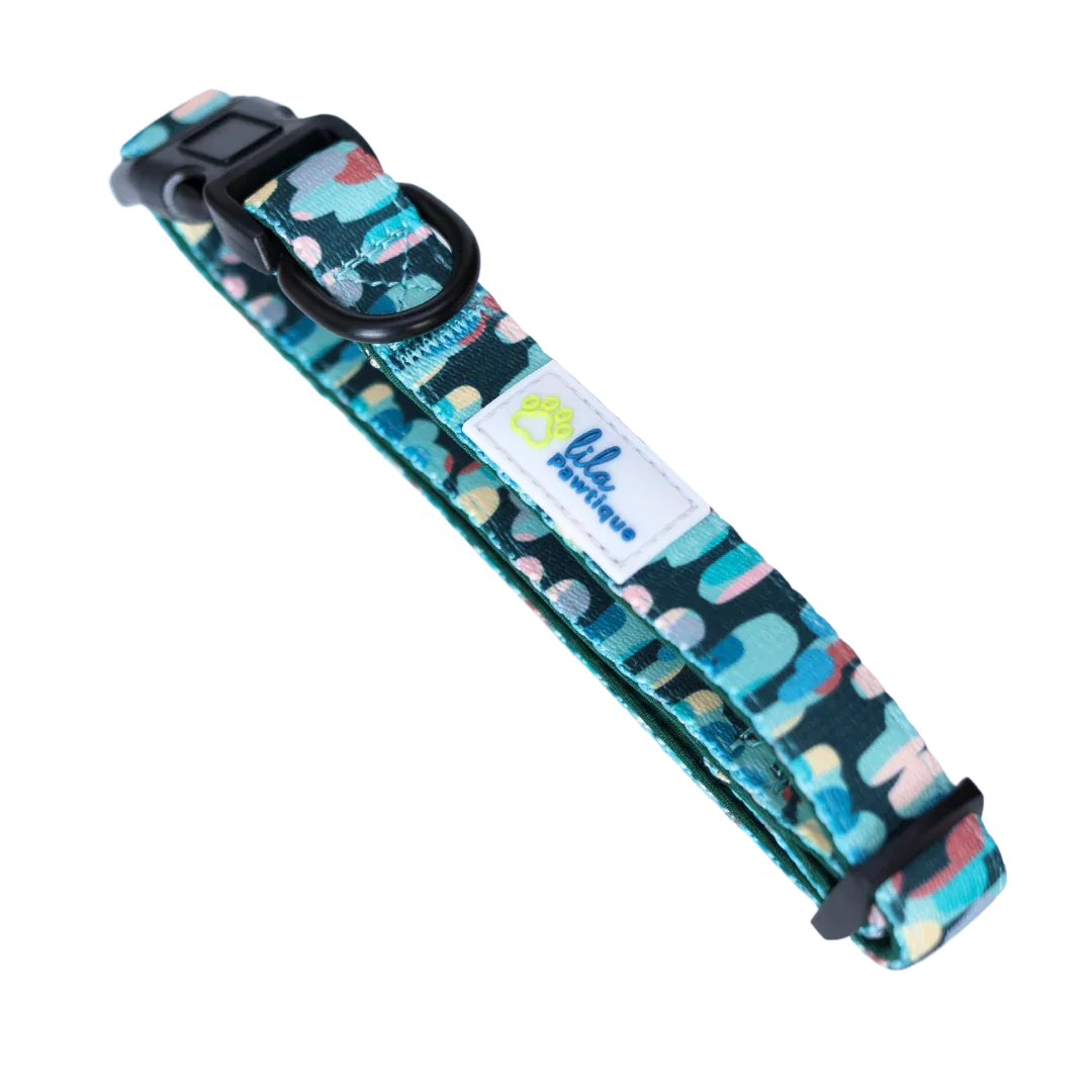 Colorful patterned dog collar with black buckle and lila pawtique logo tag