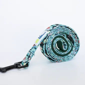 Rolled green camouflage dog leash with black metal clasp on white background