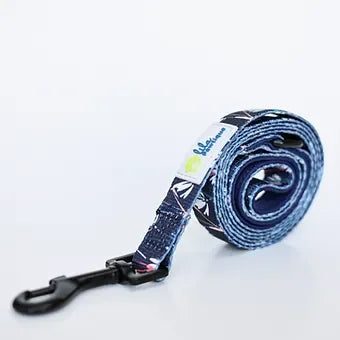 Rolled navy blue dog leash with white pattern and black clip on white background