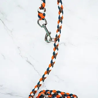 Braided dog leash with orange, brown, white, and blue colors on marble background