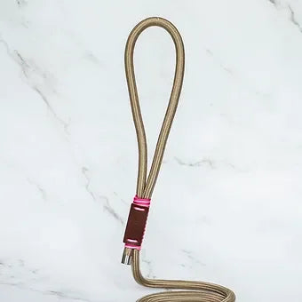 Flexible gold braided charging cable with pink accents on marble background