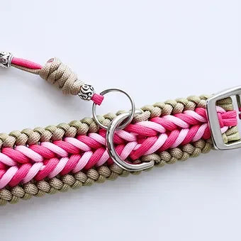 Handmade pink and beige paracord dog collar with metal buckle and D-ring on white background