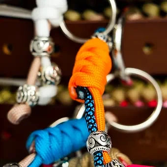 Colorful paracord keychains with metal beads and knotted details on a keyring