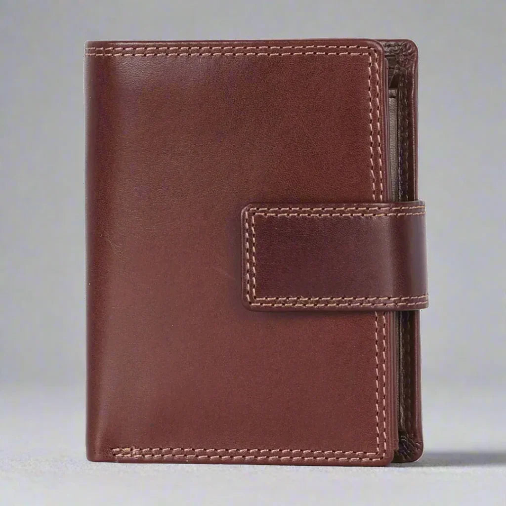 Brown leather wallet with strap closure on light background