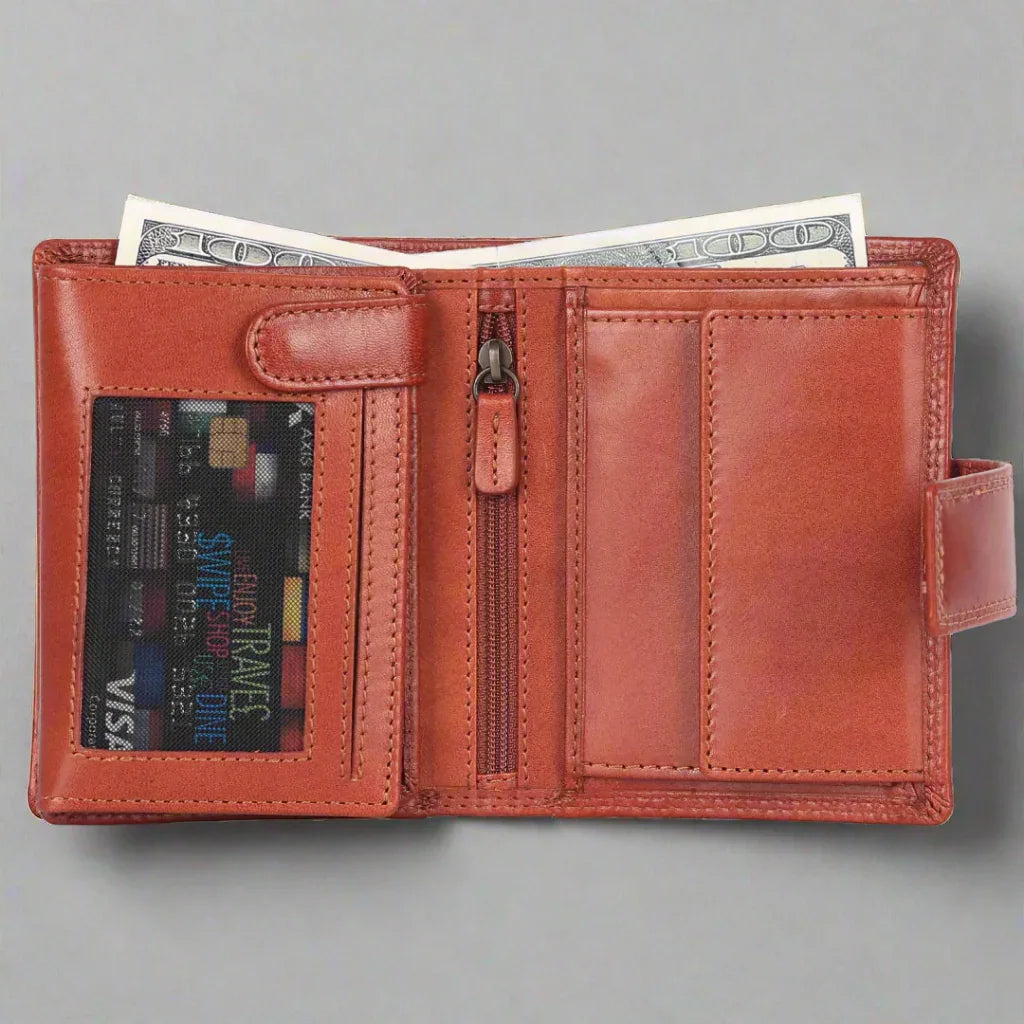 Open cognac leather wallet with cash, card slot, and zipper pocket on gray background