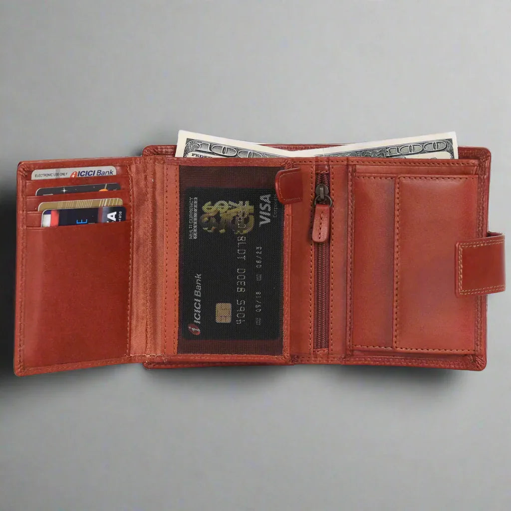 Open cognac leather wallet with cards, cash, and zipper pocket on grey background