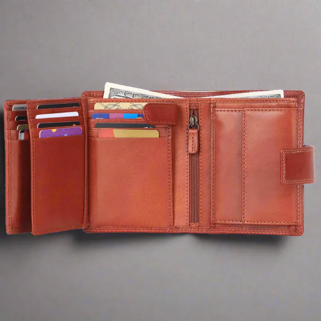 Open cognac leather wallet with card slots, cash compartments, and zippered pocket on gray background