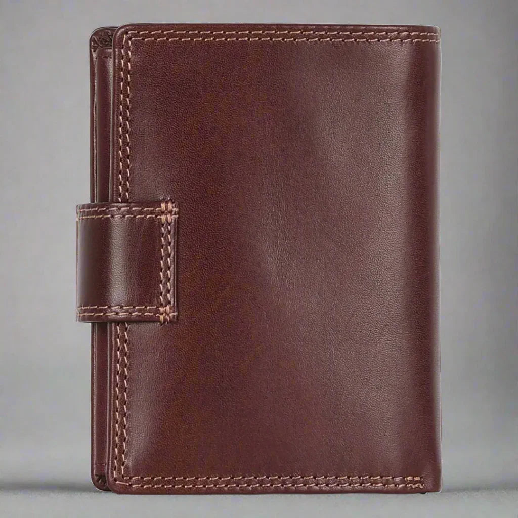 Brown leather bifold wallet with snap closure on gray background