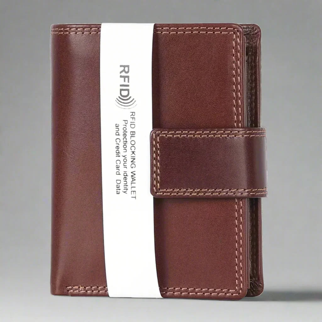Brown leather RFID blocking wallet with clasp strap on gray background