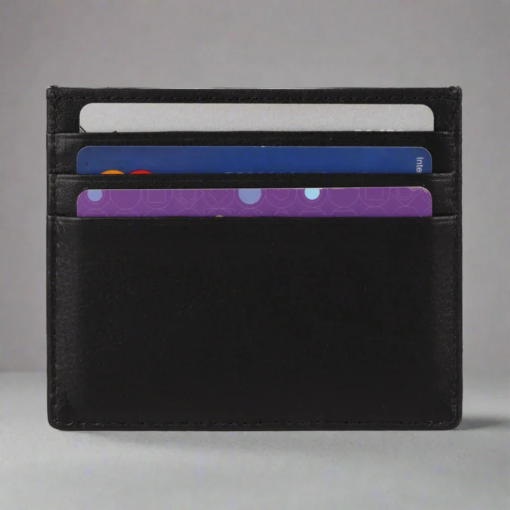 Black leather minimalist card holder wallet with three credit cards on gray background
