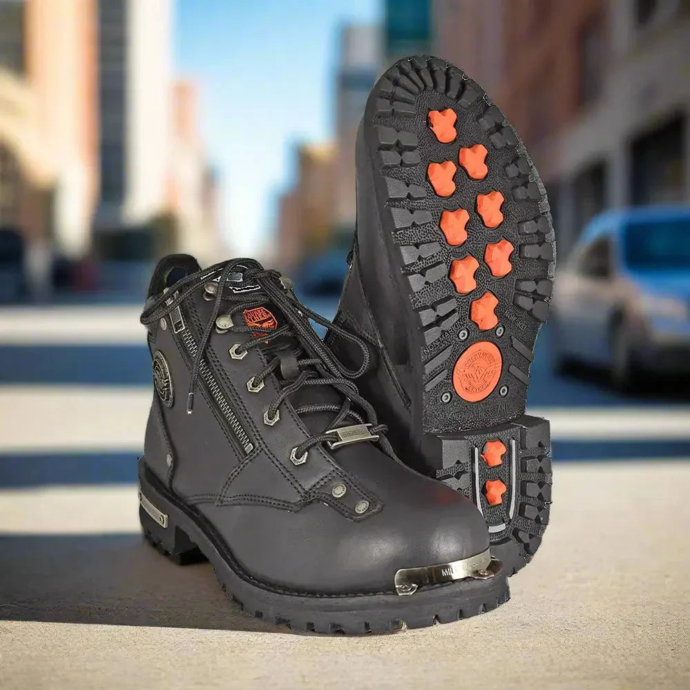 Black motorcycle boots with metal toe cap and orange-grip sole on city street