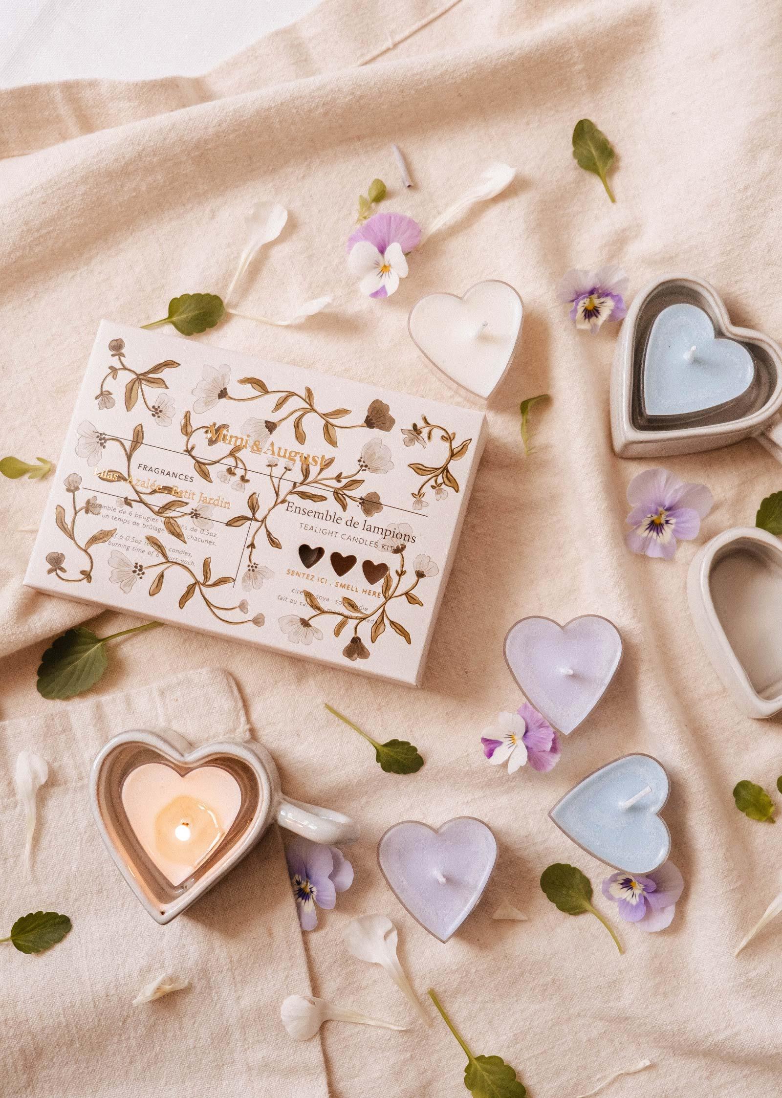 Heart-shaped tealight candles in pastel colors with floral accents and Mimi & August box on fabric.