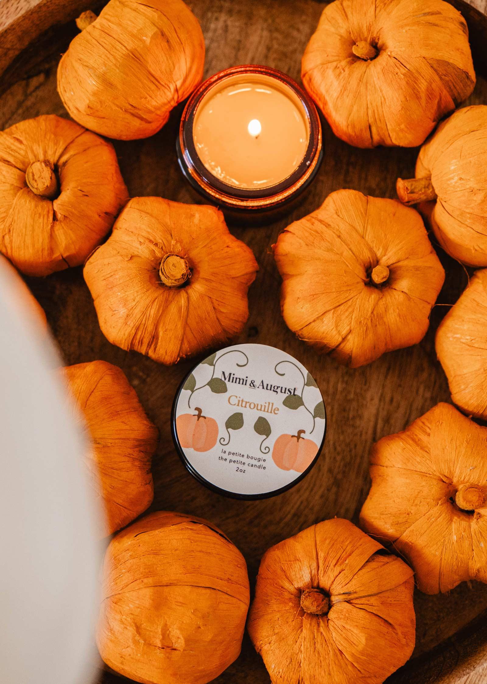 Citrouille reusable candle 2oz by Mimi & August surrounded by decorative pumpkins