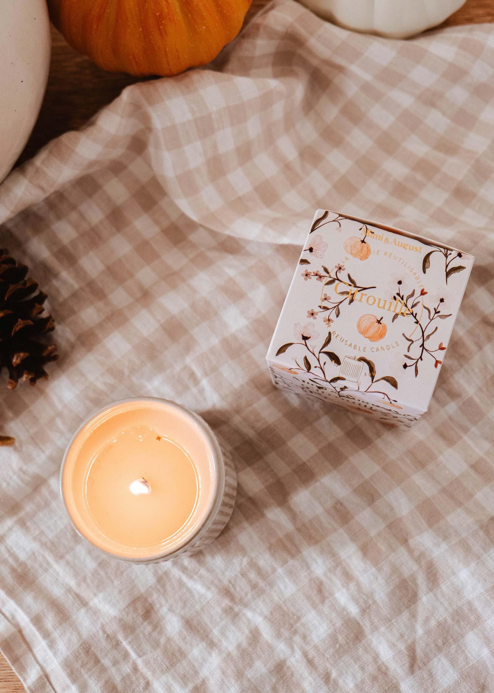 Citrouille soy wax candle and box on checkered cloth with pumpkins, autumn decor