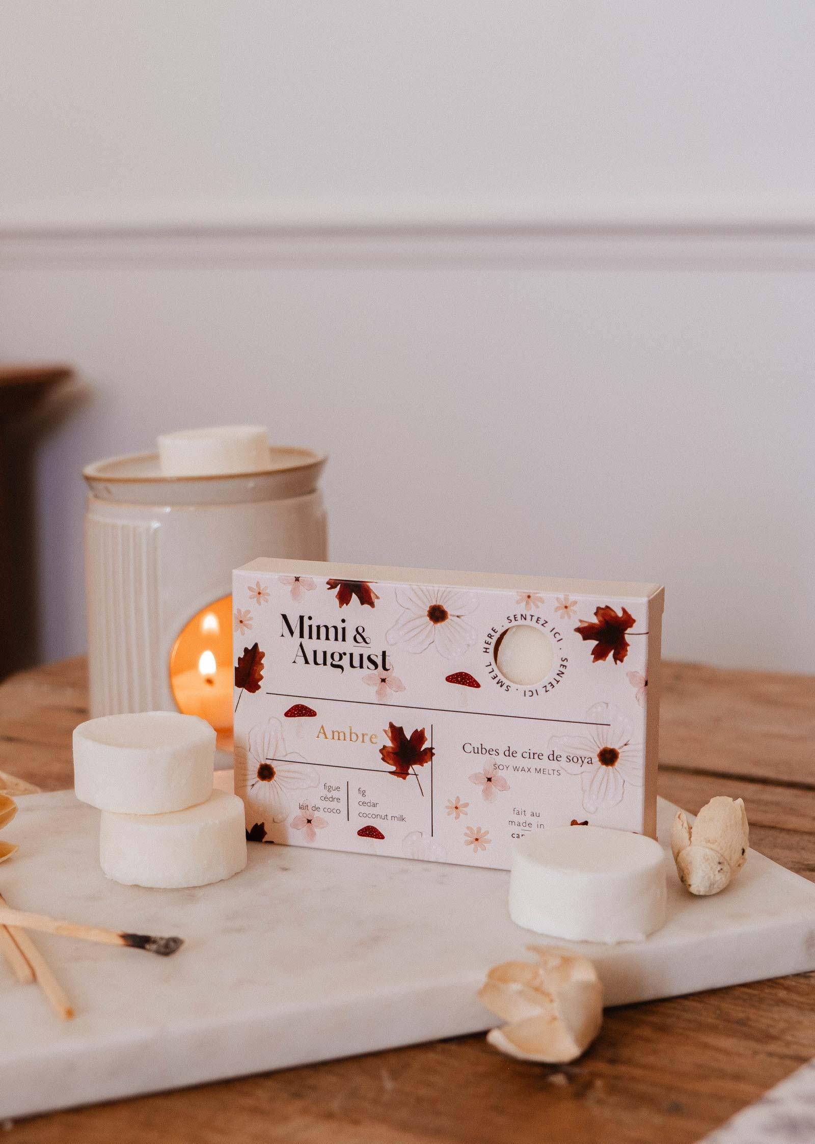 Mimi & August Ambre soy wax melts on a wooden table with ceramic warmer and botanicals