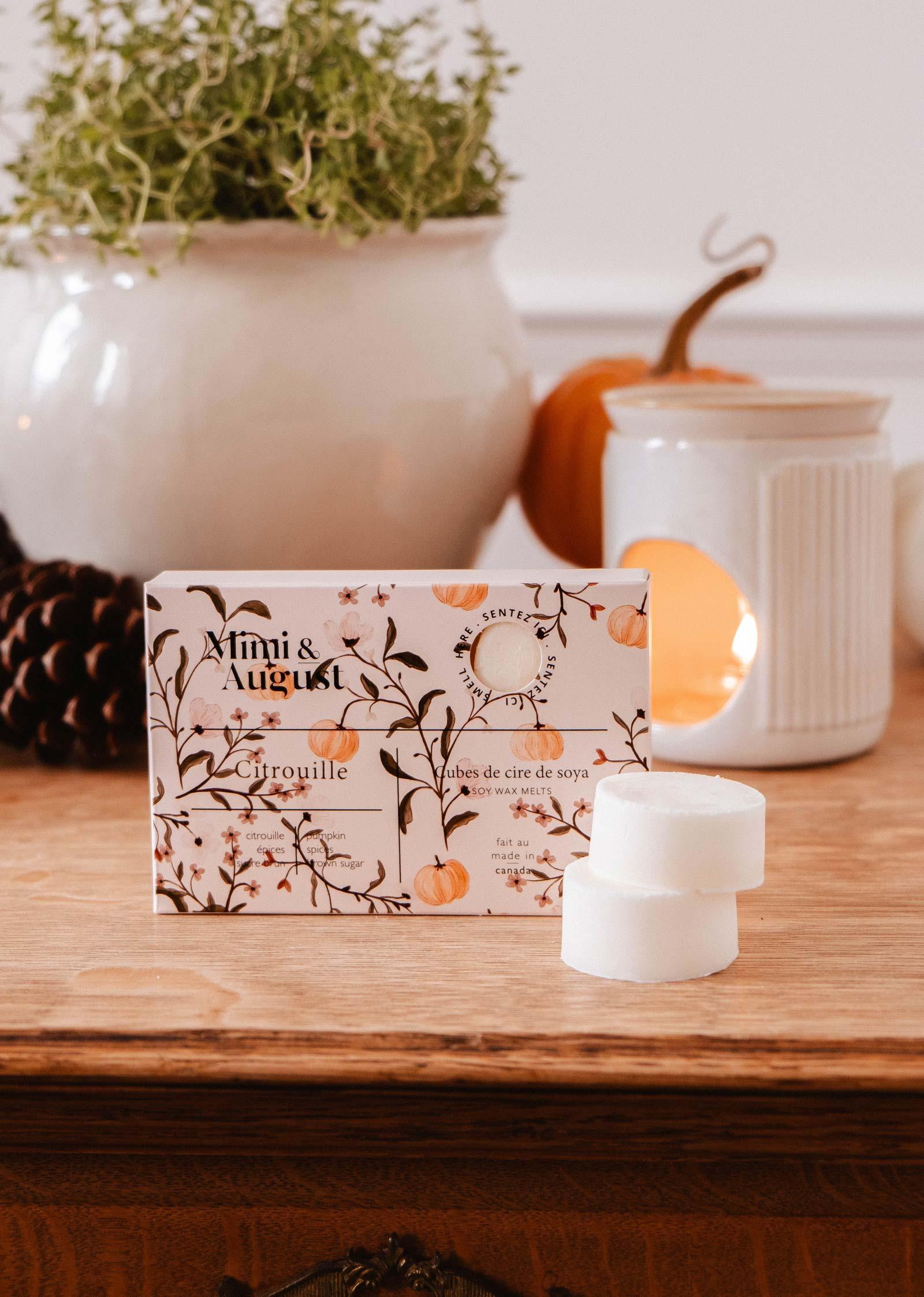 Citrouille soy wax melts by Mimi & August on wooden table with wax warmer and plant