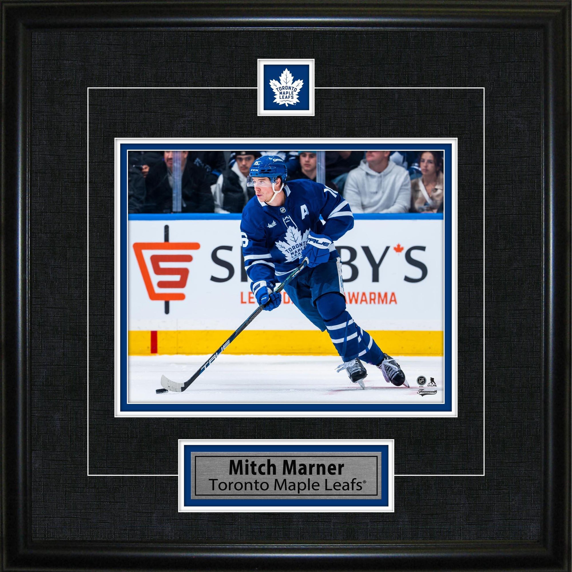 Framed photo of Toronto Maple Leafs player in blue jersey skating on ice with hockey stick