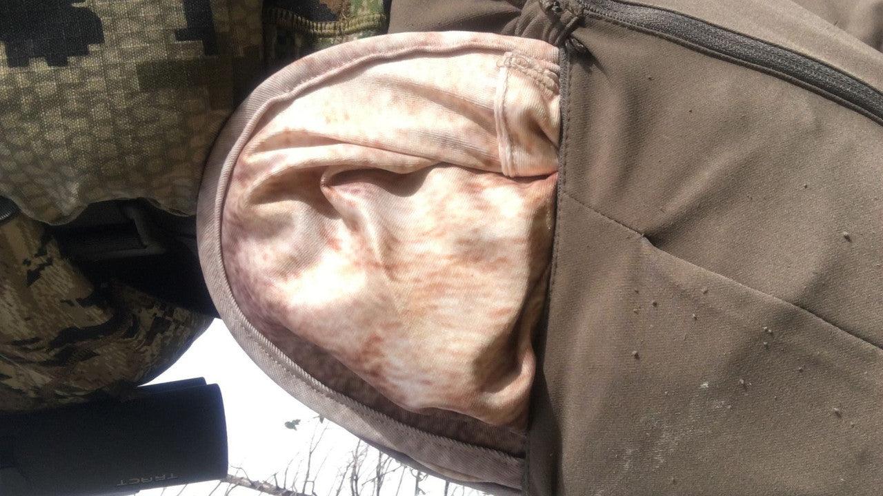 Close-up of tan hunting backpack pocket with soft fleece lining and camouflage pattern