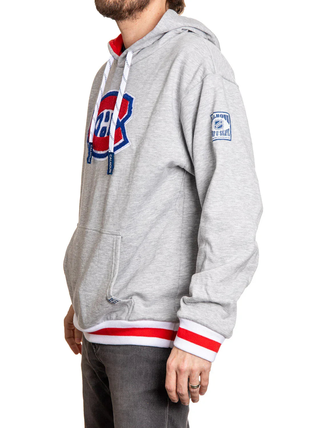 Side view of man in grey Montreal Canadiens logo hoodie with red and white striped cuffs