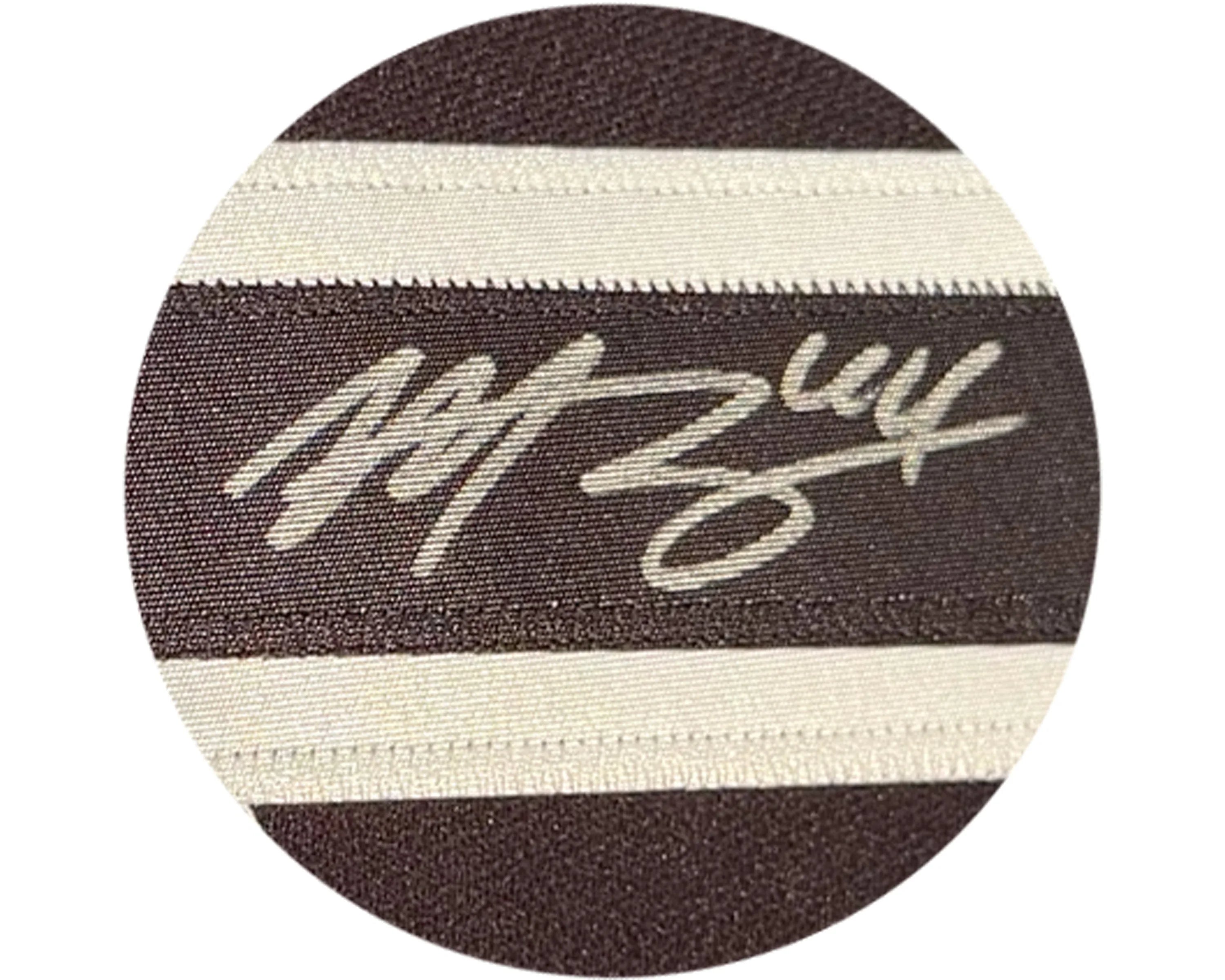Brown and white striped fabric with a white embroidered signature design