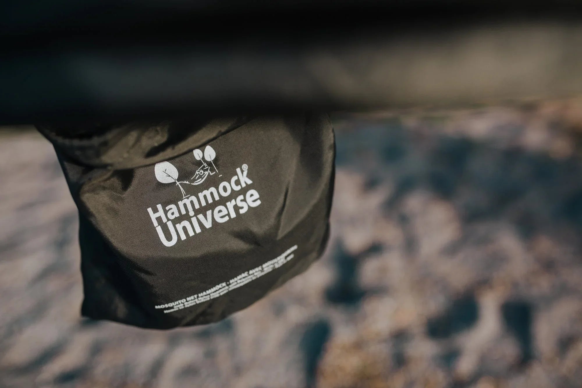 Hammock Universe branded black hammock bag outdoors on natural ground