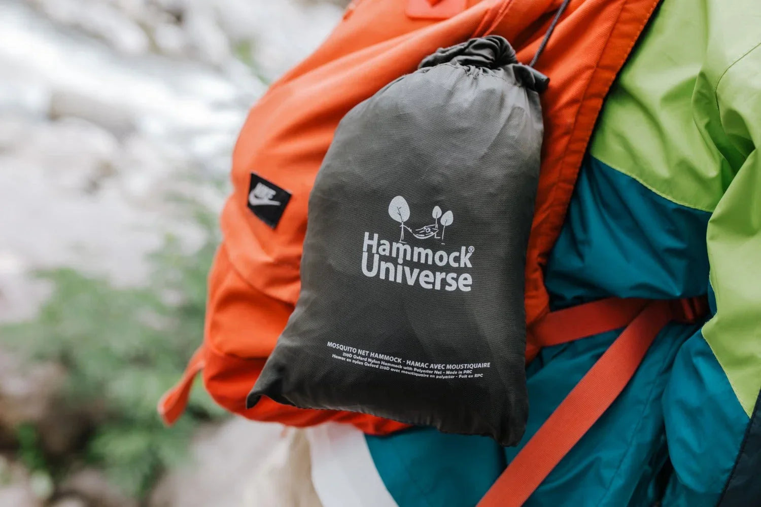 Hammock Universe mosquito net hammock bag attached to orange backpack outdoors