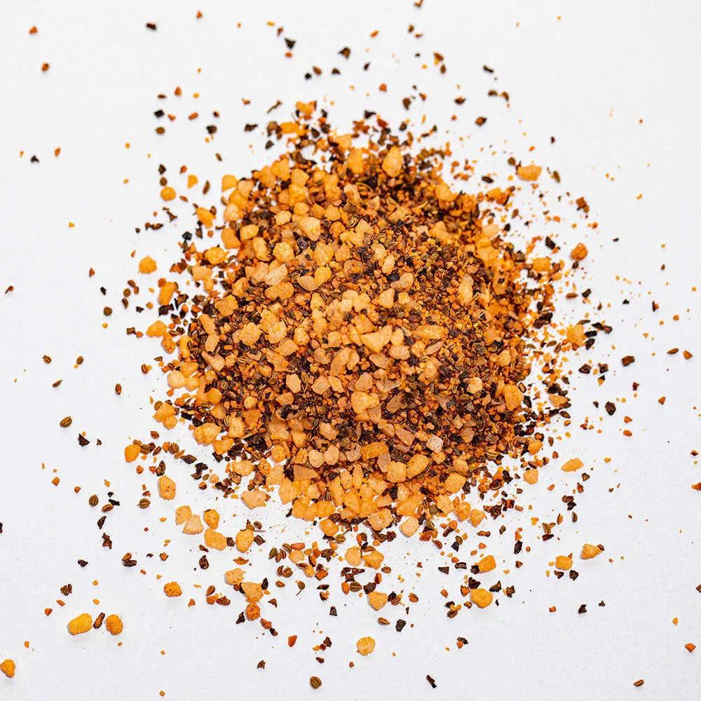 Pile of coarse brisket seasoning rub with pepper and spices on white background