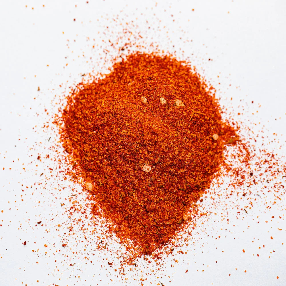 Pile of red chicken seasoning spice blend on white background