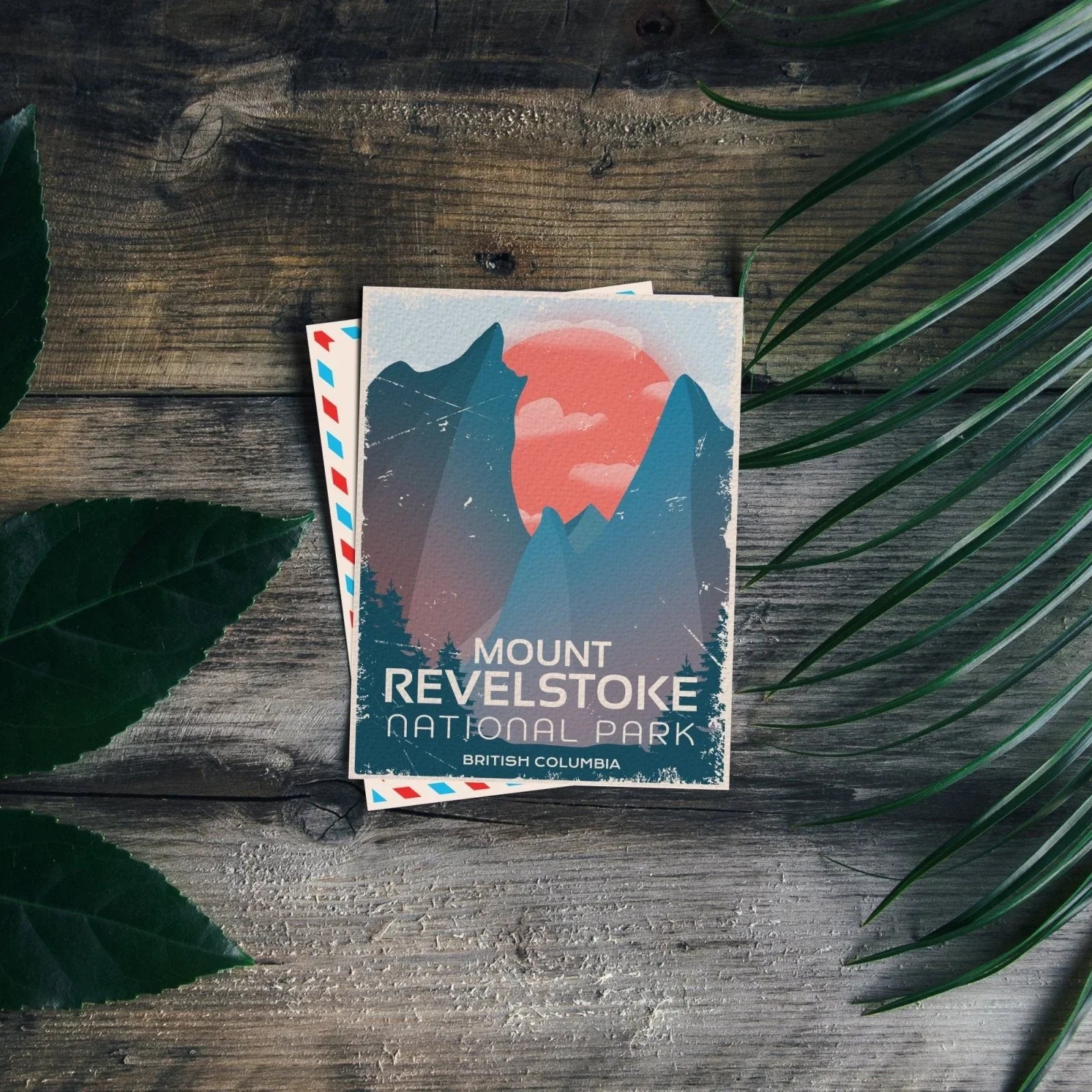 Mount Revelstoke National Park postcard on rustic wood with leafy plant accents
