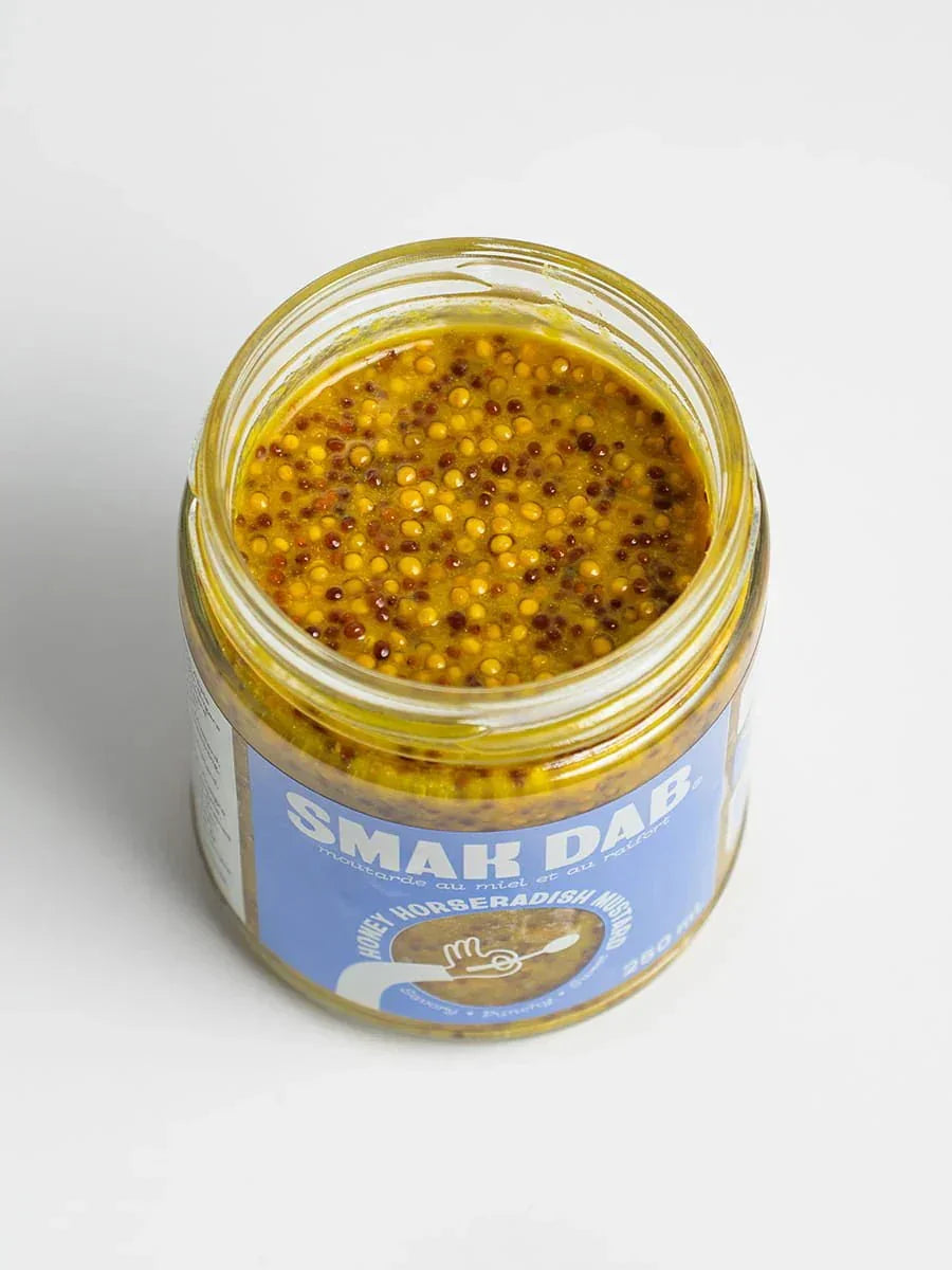 Open jar of Smak Dab honey horseradish mustard on a white background
