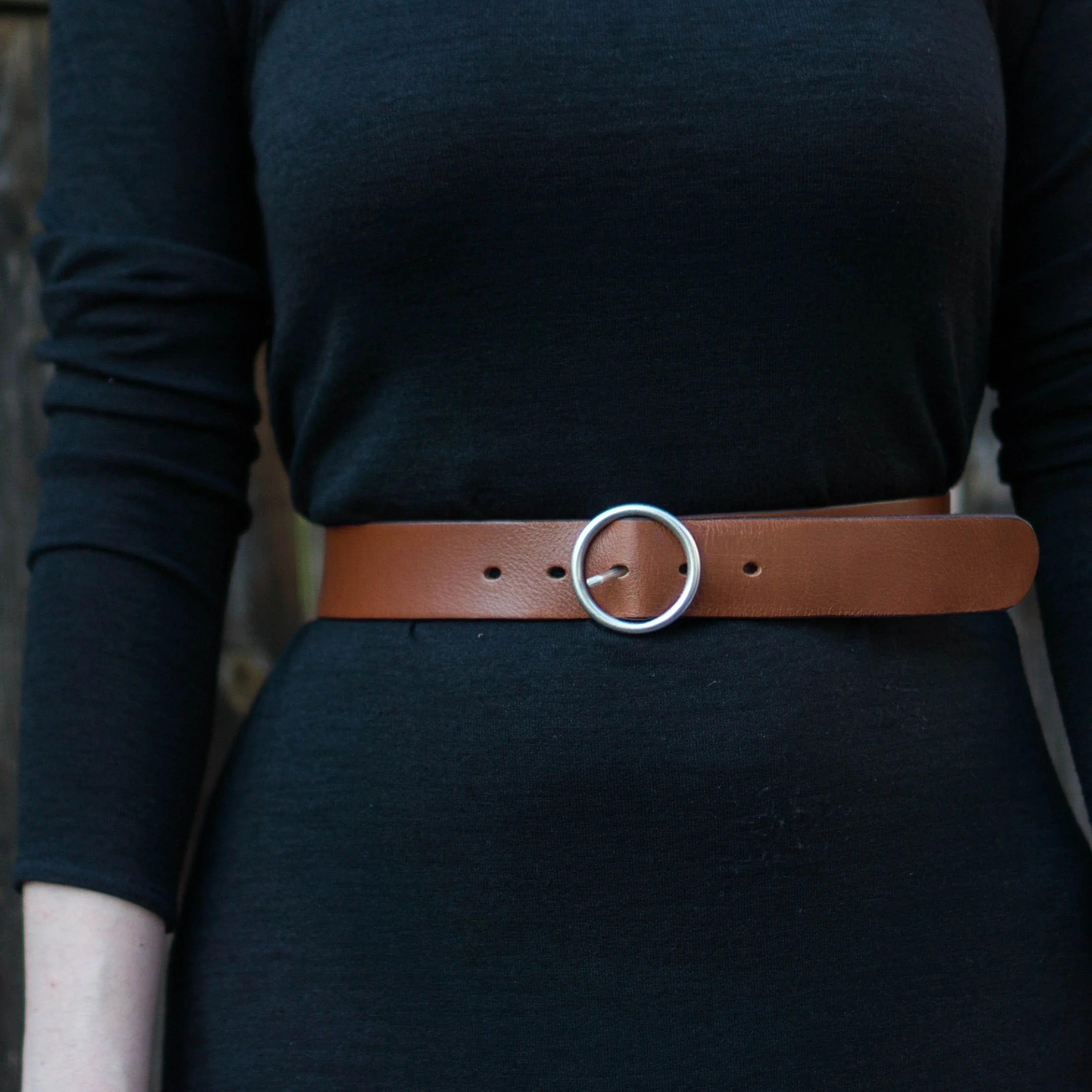 Brown leather belt with silver round buckle on black dress