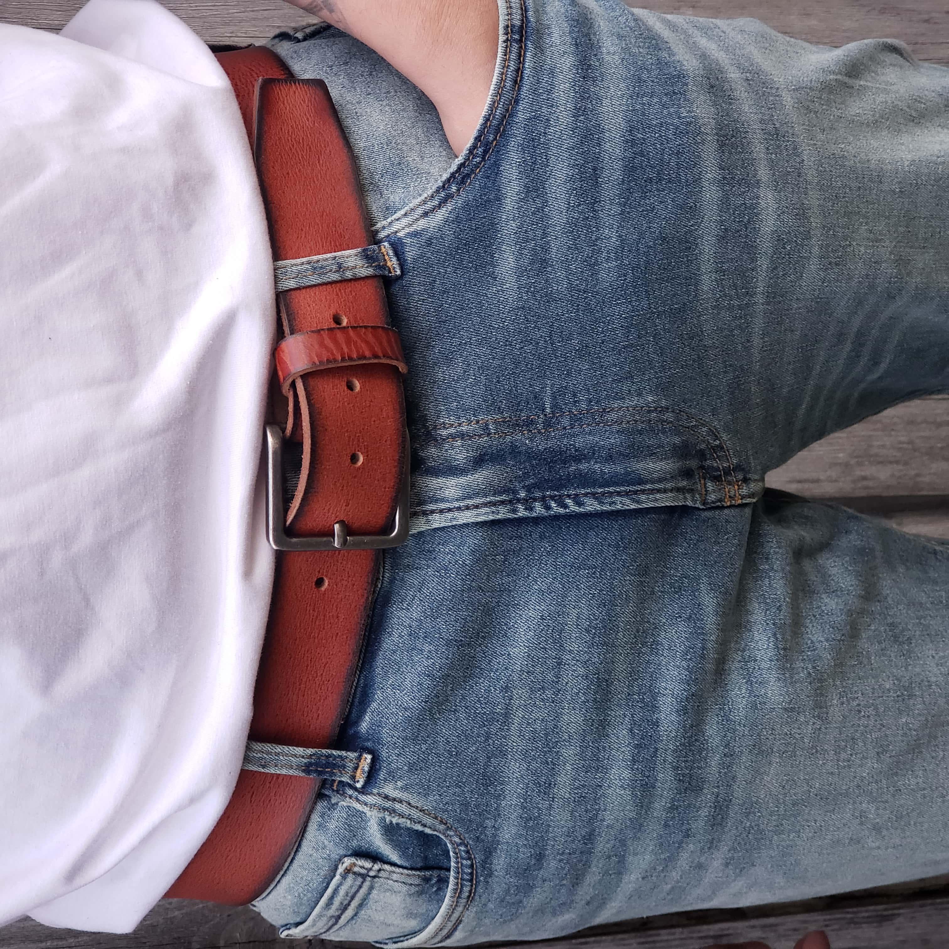 Brown leather belt on blue jeans with white shirt, casual fashion style