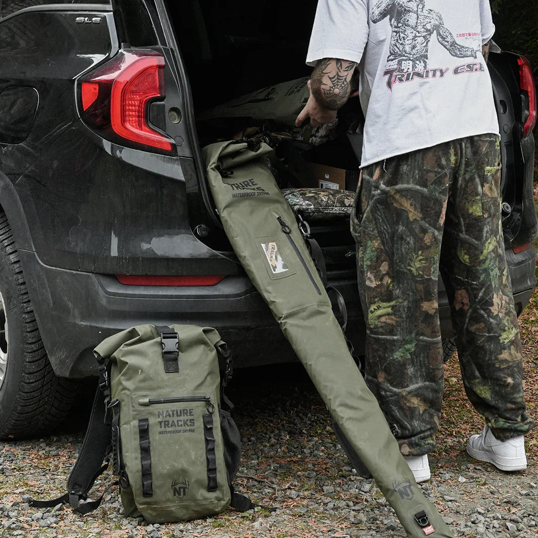 Man unloading Nature Tracks waterproof backpack and rod bag from SUV outdoors