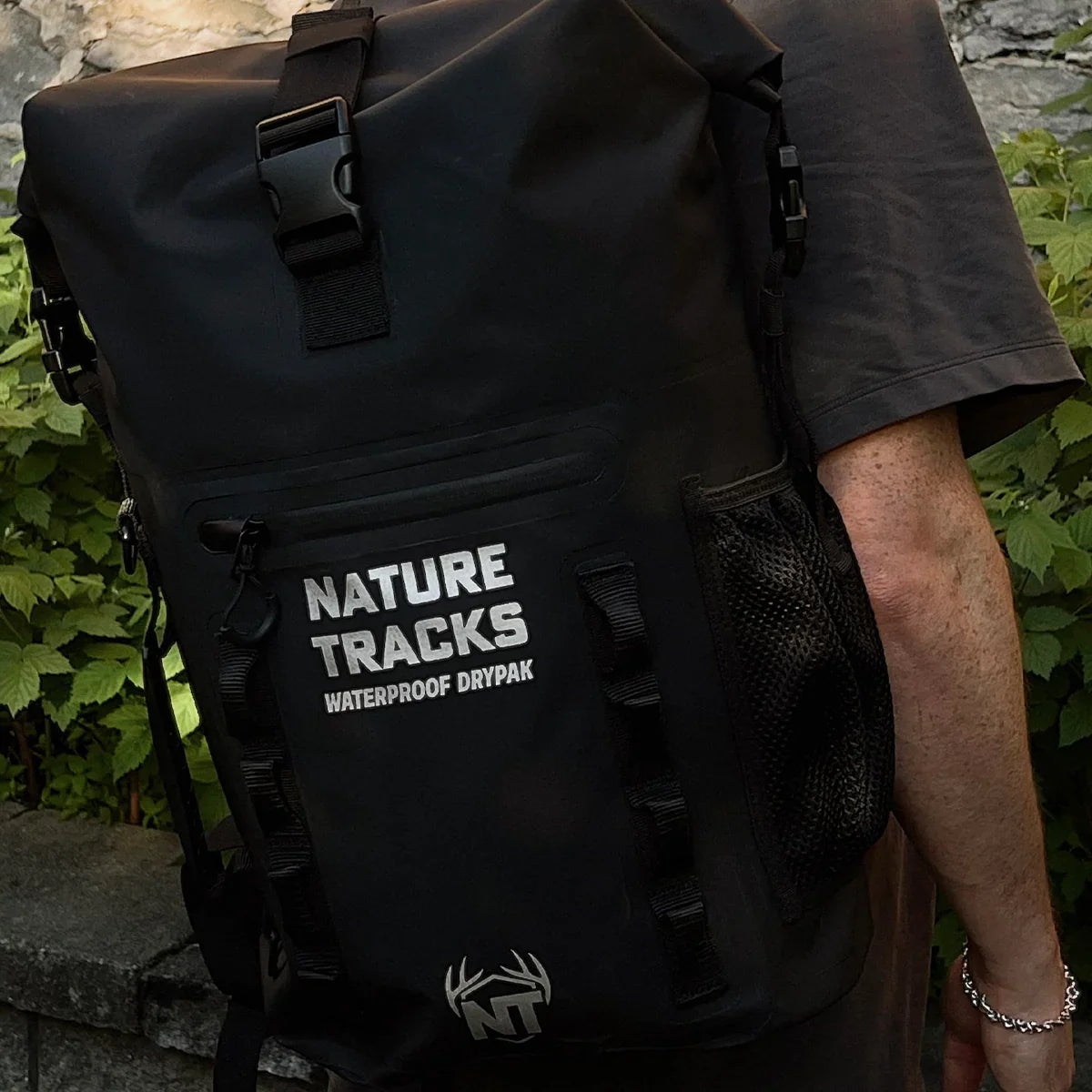 Person wearing a black Nature Tracks waterproof dry bag backpack outdoors