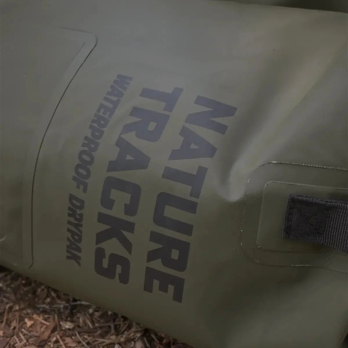 Olive green Nature Tracks waterproof drypak bag on ground outdoors