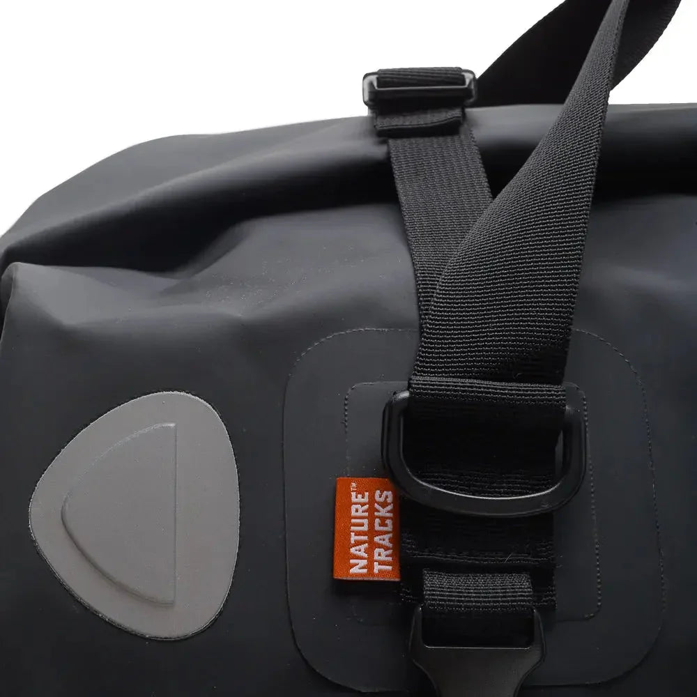 Close-up of black Nature Tracks waterproof bag with buckle and branded tag