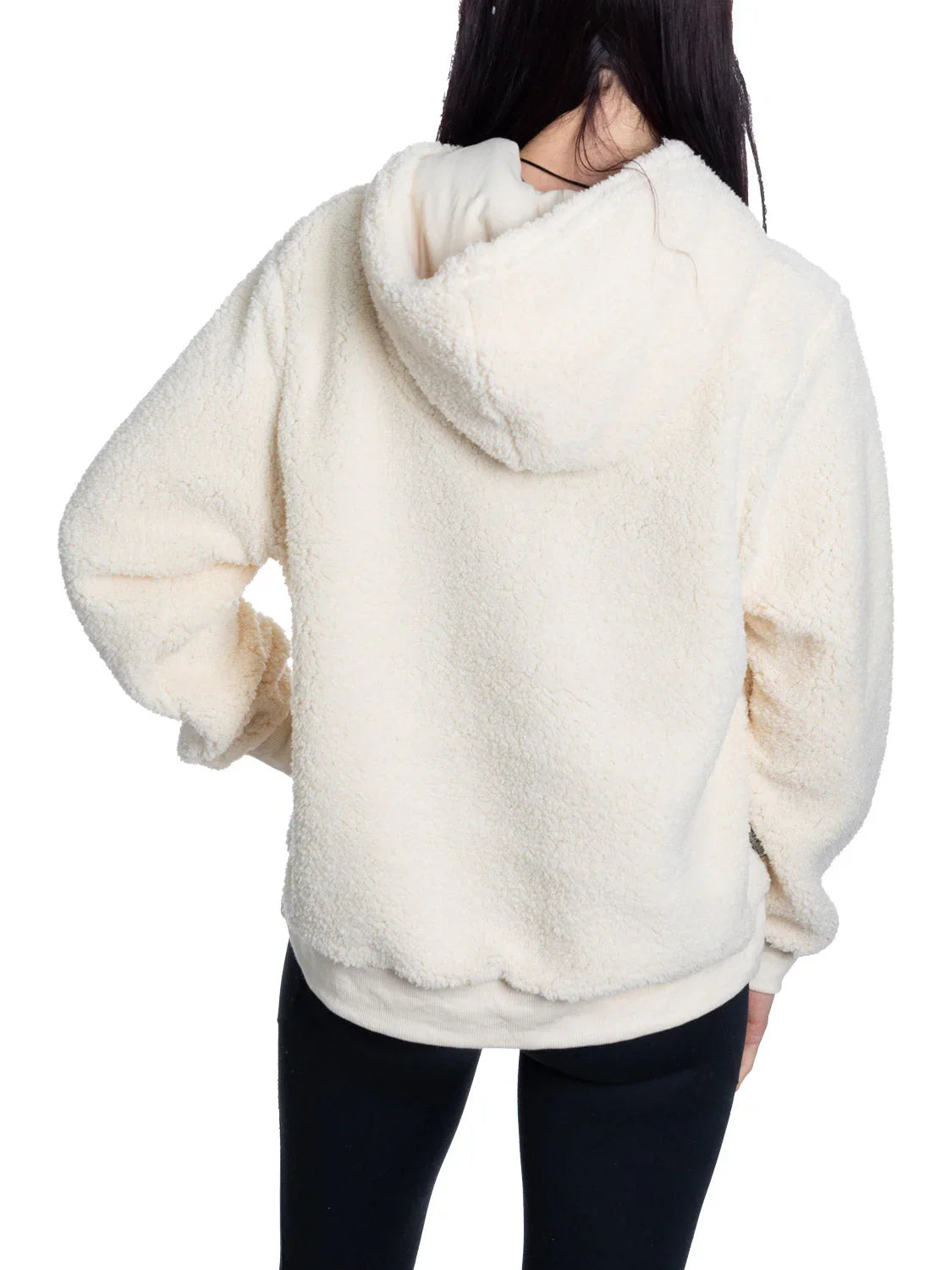 Back view of person wearing cream sherpa hoodie and black leggings on white background