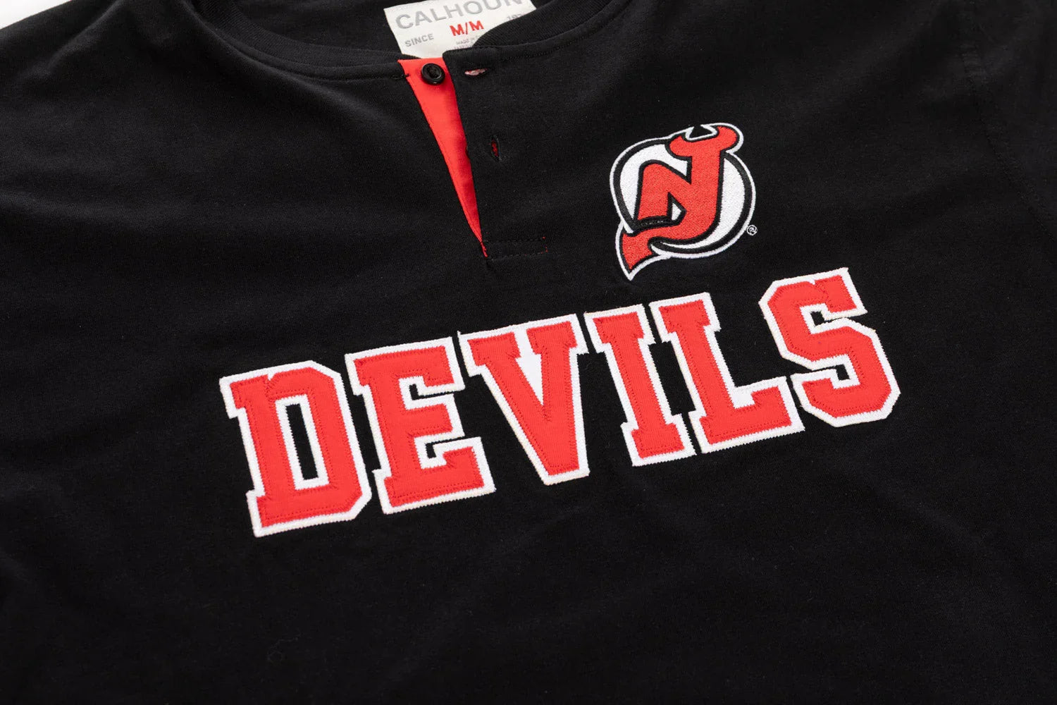Black Devils henley shirt with embroidered red logo and lettering detail
