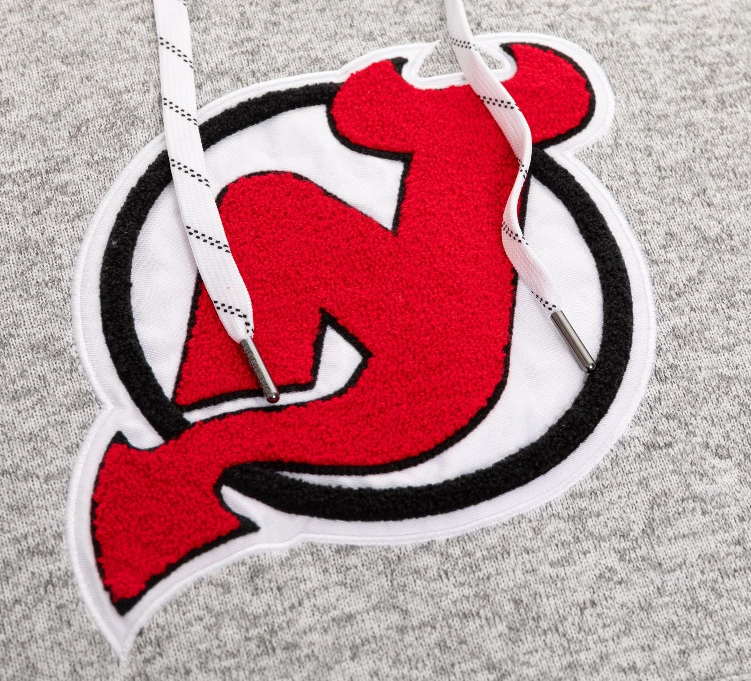 Red and black devil logo patch on grey hoodie with white drawstrings