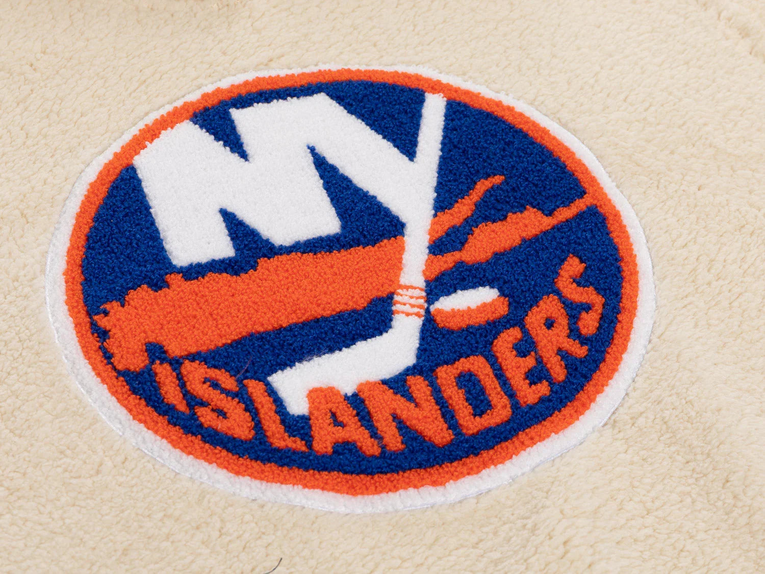 New York Islanders sherpa fleece patch close-up with team logo on beige fabric
