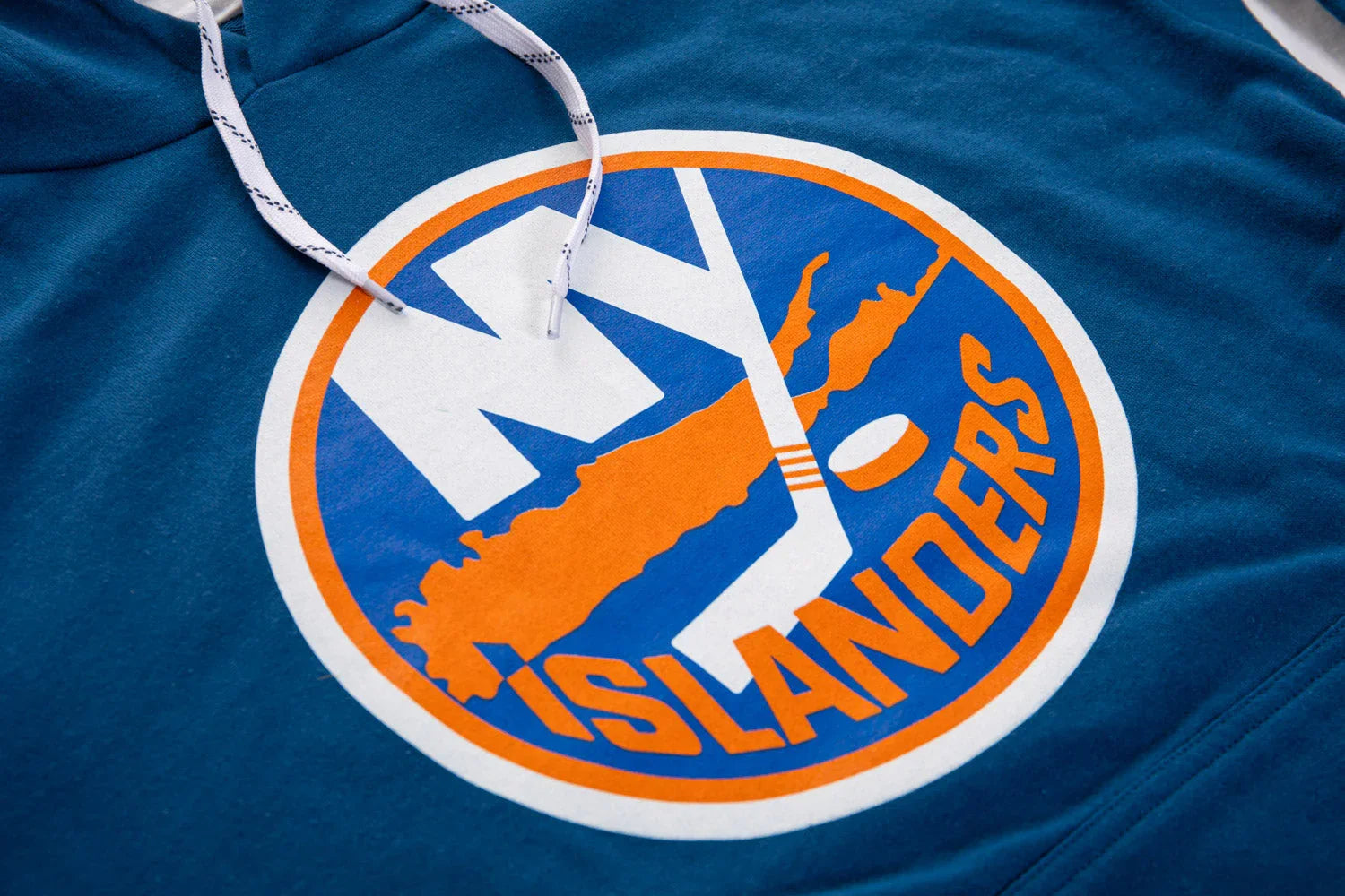 Close-up of NY Islanders varsity hoodie logo in blue, orange, and white colors